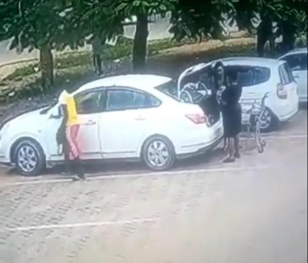 CCTV captures moment a young boy robbed a woman while offloading shopping bags in her trunk (Video)