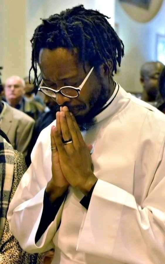 Man with dreadlocks as Catholic Priest