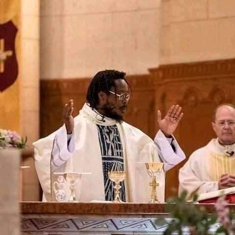 Man with dreadlocks as Catholic Priest