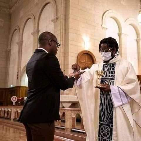 Man with dreadlocks as Catholic Priest