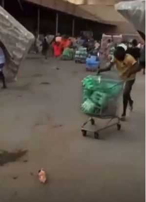 Residents cart away valuable items as fire guts Next Cash and Carry  supermarket in Abuja (Video)