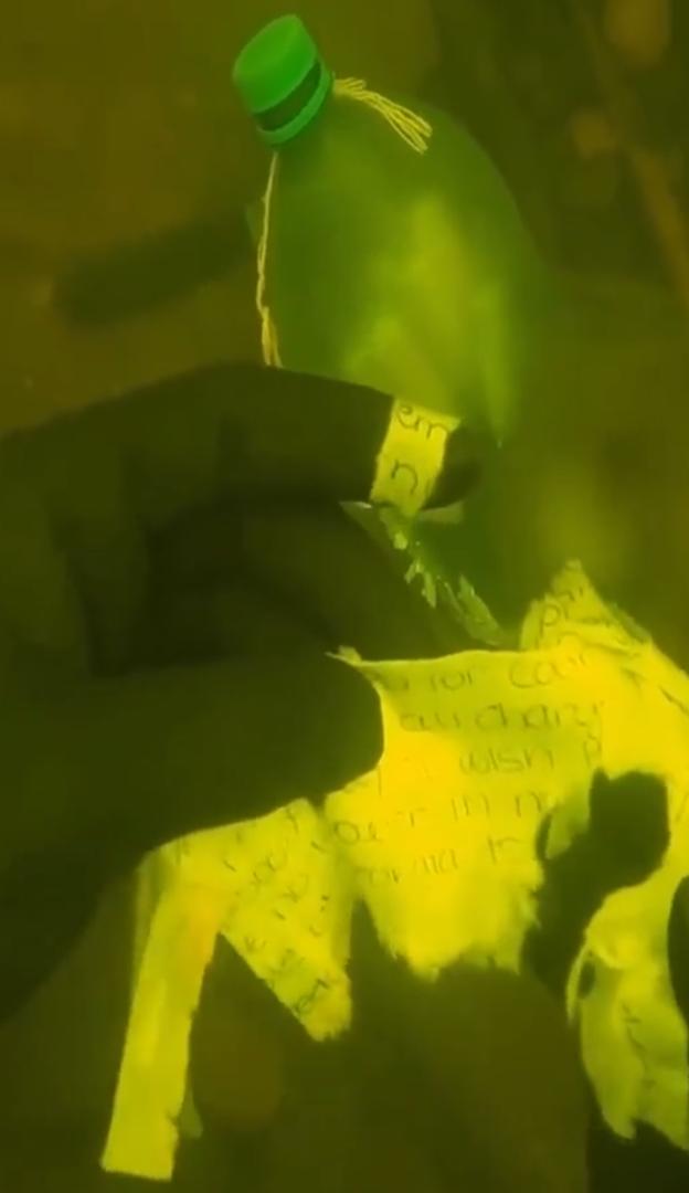 Diver discovers mysterious bottle underwater with names tied to knives (Video)