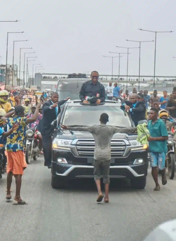 yusuf alami boy standing in front of peter obi's convoy