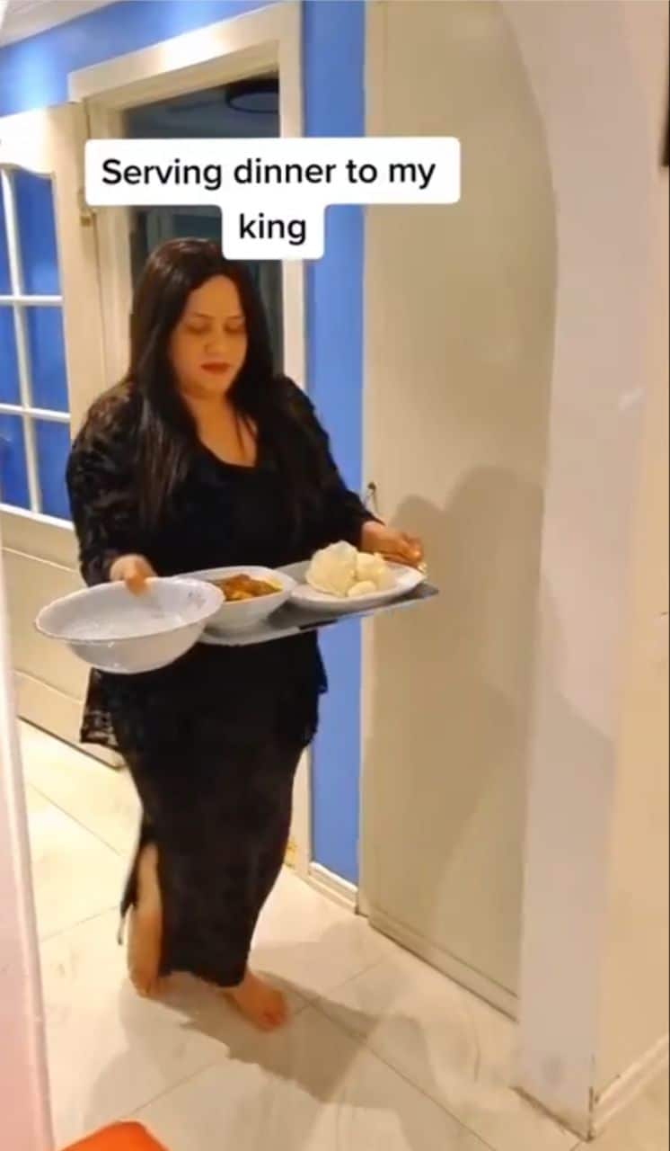 Caucasian woman stirs reactions following traditional way of serving Nigerian husband food (Video)