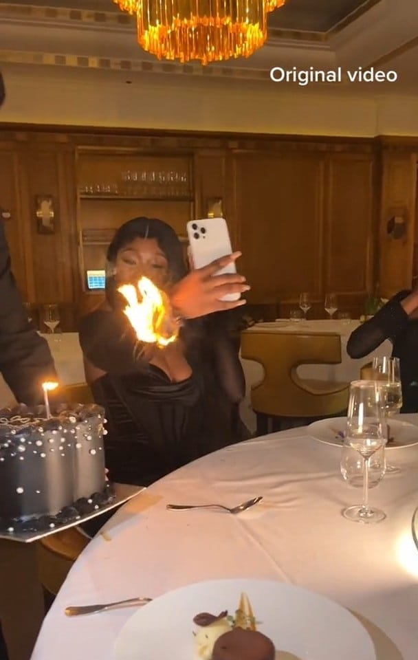 Moment lady's outfit catches fire while making video of birthday cake