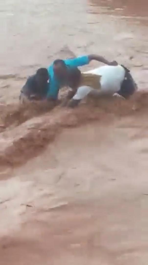 Moment onlookers rescue man trapped in flood (Video)