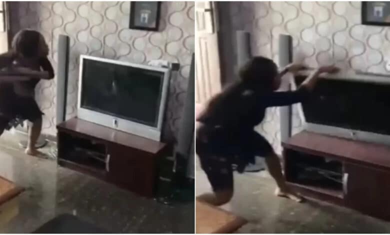 Nigerian lady destroys boyfriend’s TV for allegedly cheating on her with her best friend (Video)