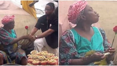 Old woman selling groundnut receives rose flower, blows kiss to young man who gave it to her