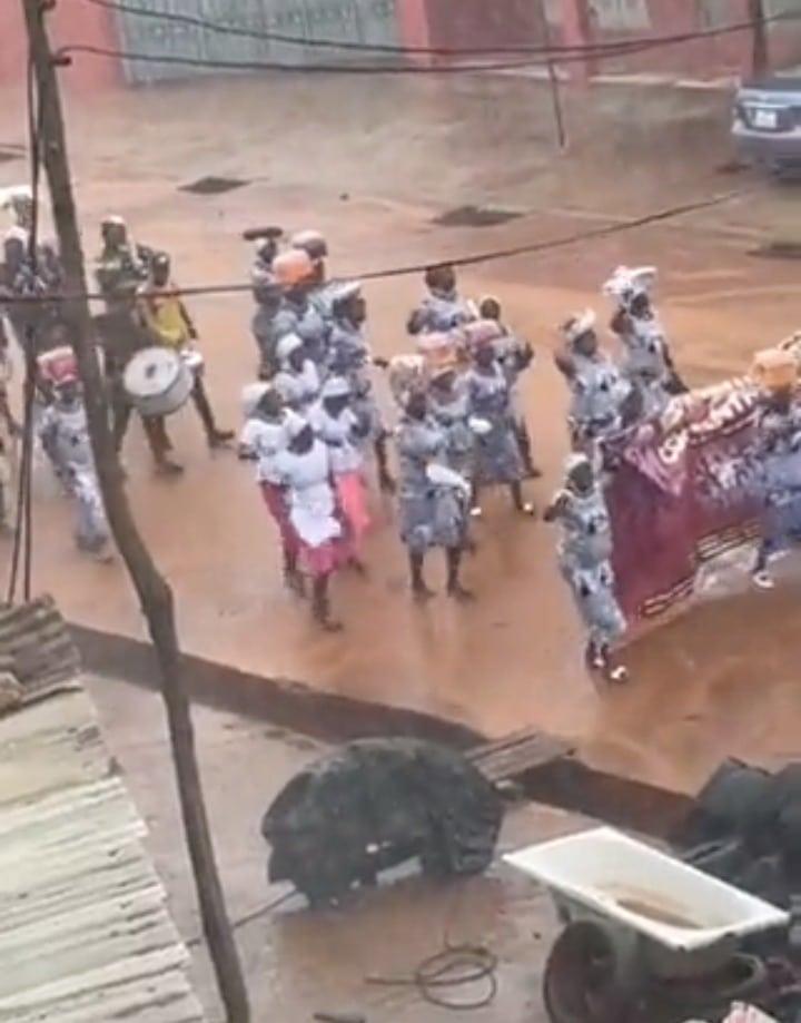 Pastor and wife chill inside car as church members walk in the rain during crusade