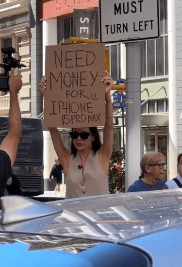  "I need money for Apple phone"  - Lady gifted latest iPhone 15 Pro Max after storming street with placard (Video)