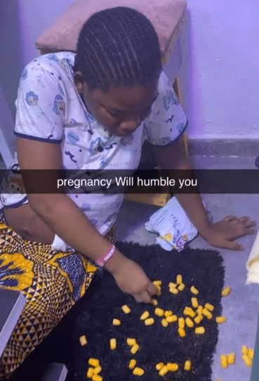 "Pregnancy will humble you" - Pregnant Nigerian woman causes buzz as she eats cheese balls from floor like baby