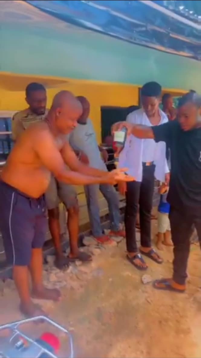 Nigerian big boy washes his father's hand with alcohol 