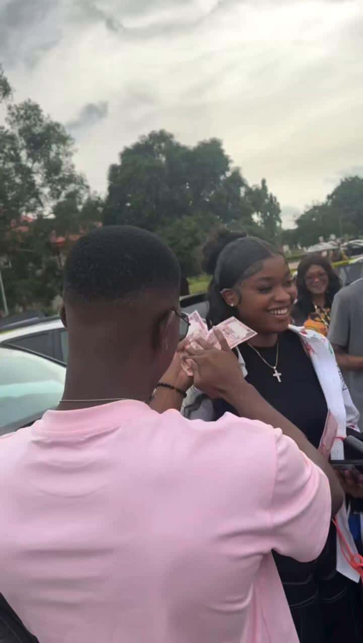 man makes it rain on his girlfriend as she graduates