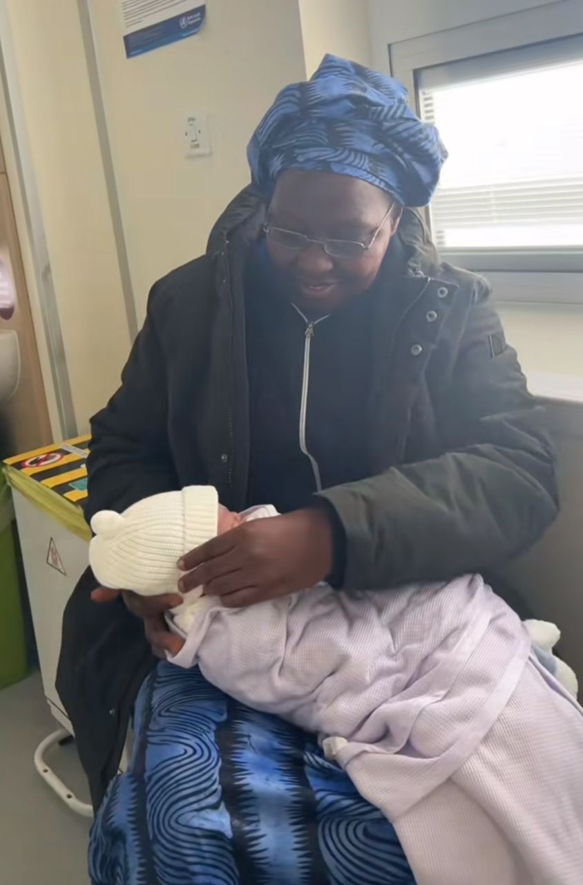 Emotional moment mother carries grandchild for the first time